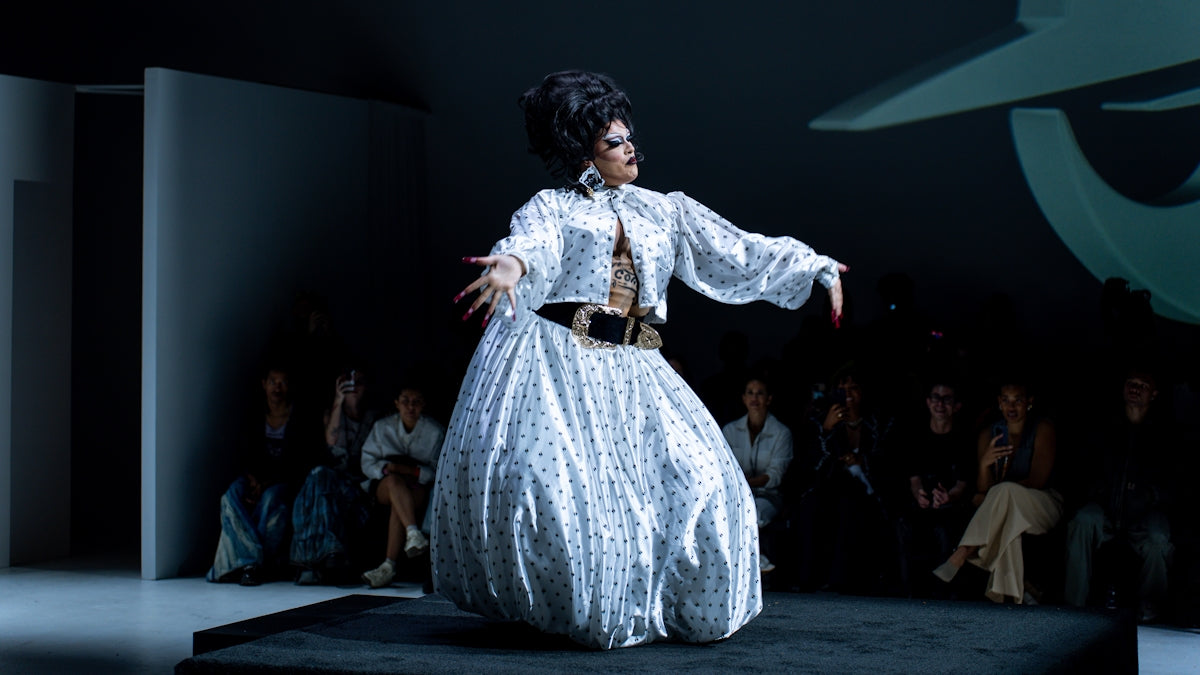 a woman in a white dress on a runway