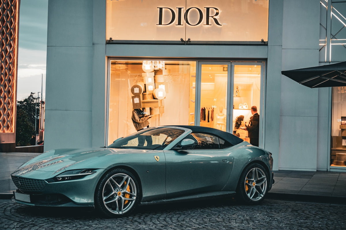 Luxury convertible car parked outside dior store.