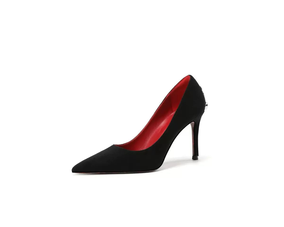 Black high-heeled shoe with red interior on a white background