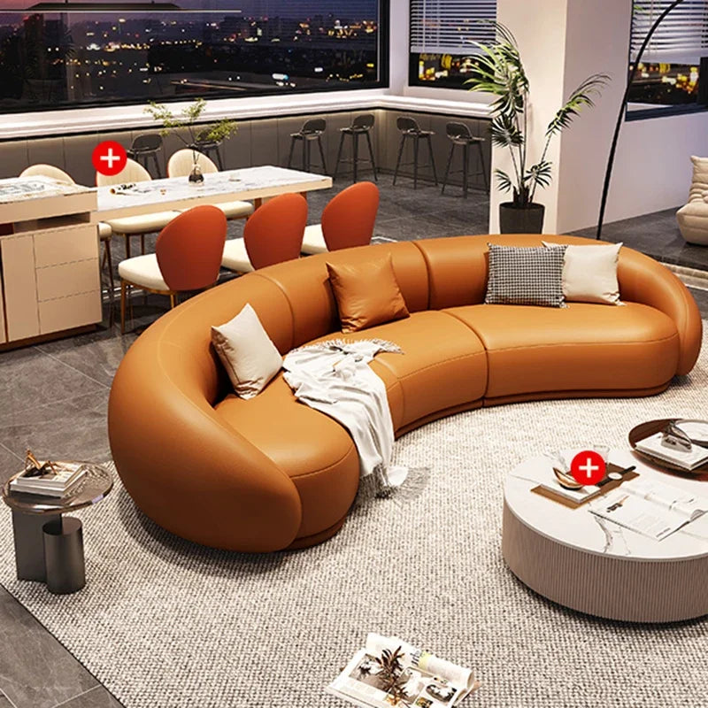 Modern living room with a curved brown leather sofa and round coffee table.