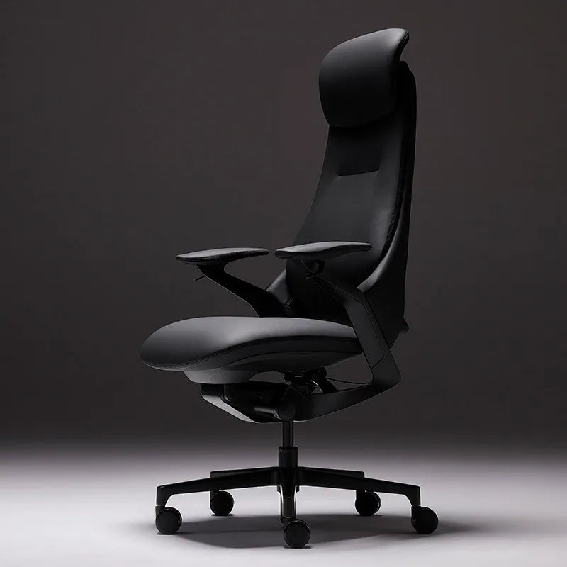 A modern black ergonomic office chair with a high back, padded headrest, adjustable armrests, and a five-wheel base, photographed against a dark gray studio background.