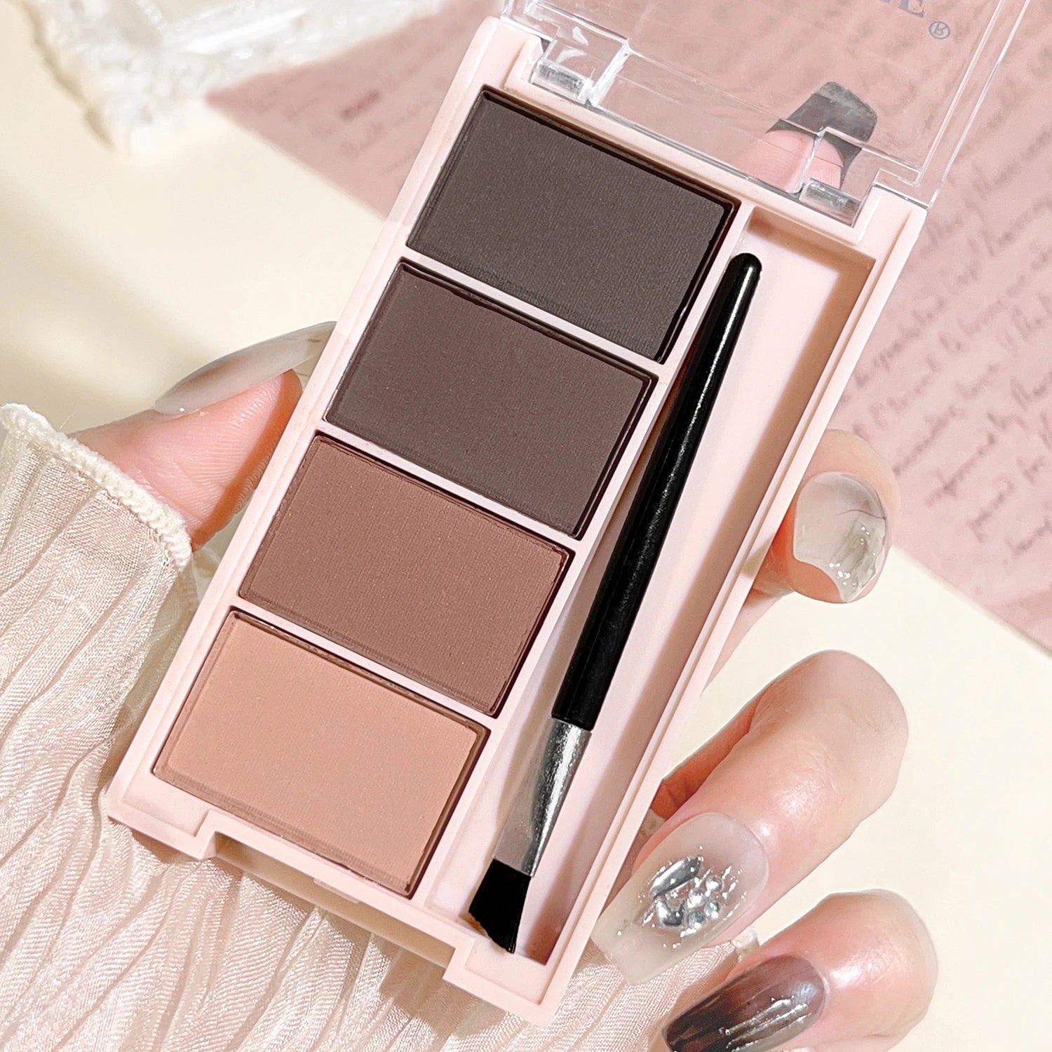 A set of 4-color eyebrow powder trays with brushes in gray and brown matte tones for long-lasting color rendering, filling and s