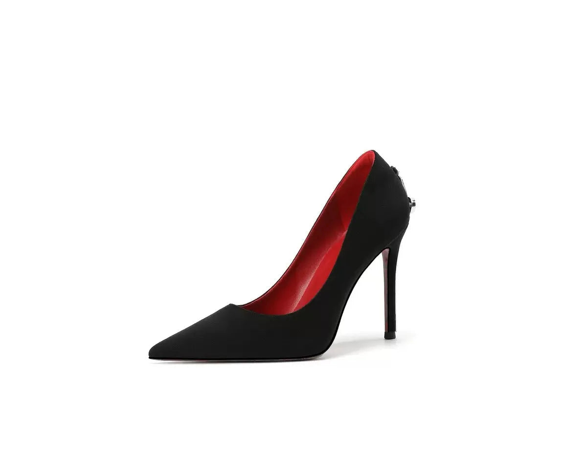 Black high-heeled shoe with red interior on a white background