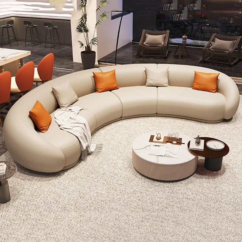 Modern living room with a curved beige sofa and orange cushions.