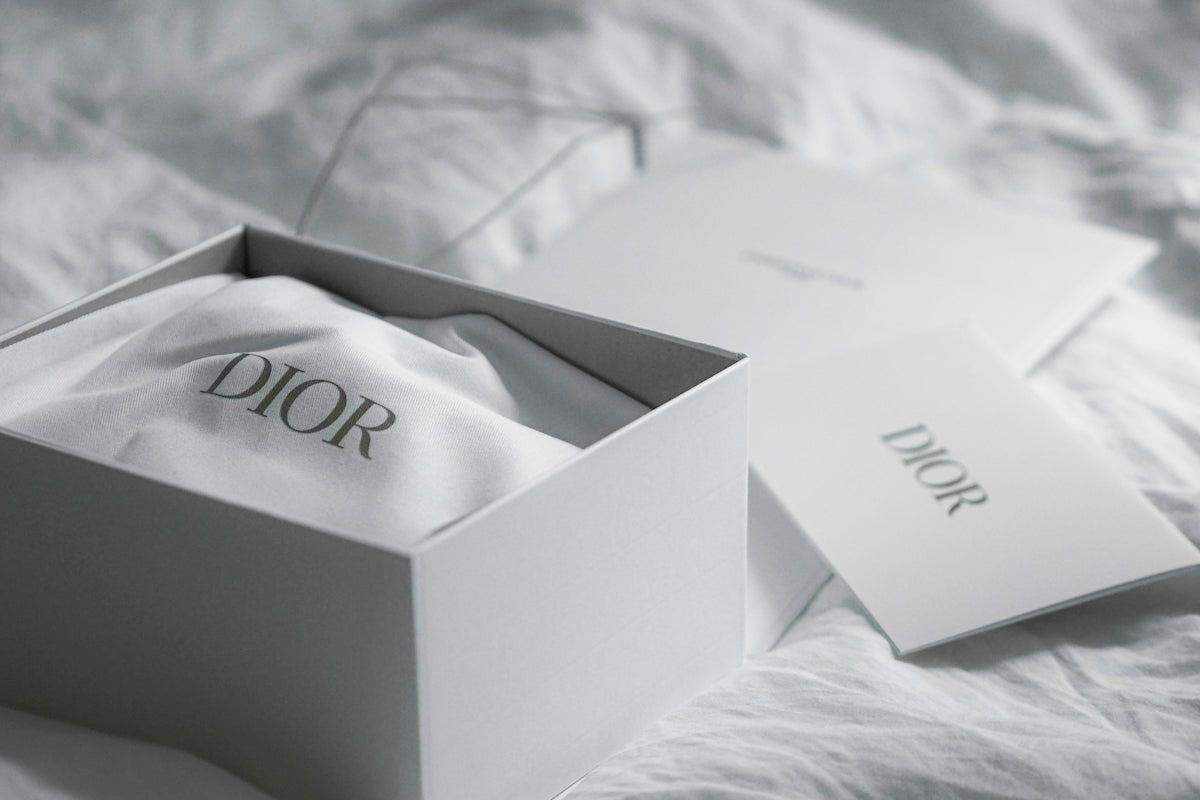 Dior box with cloth and card on white fabric