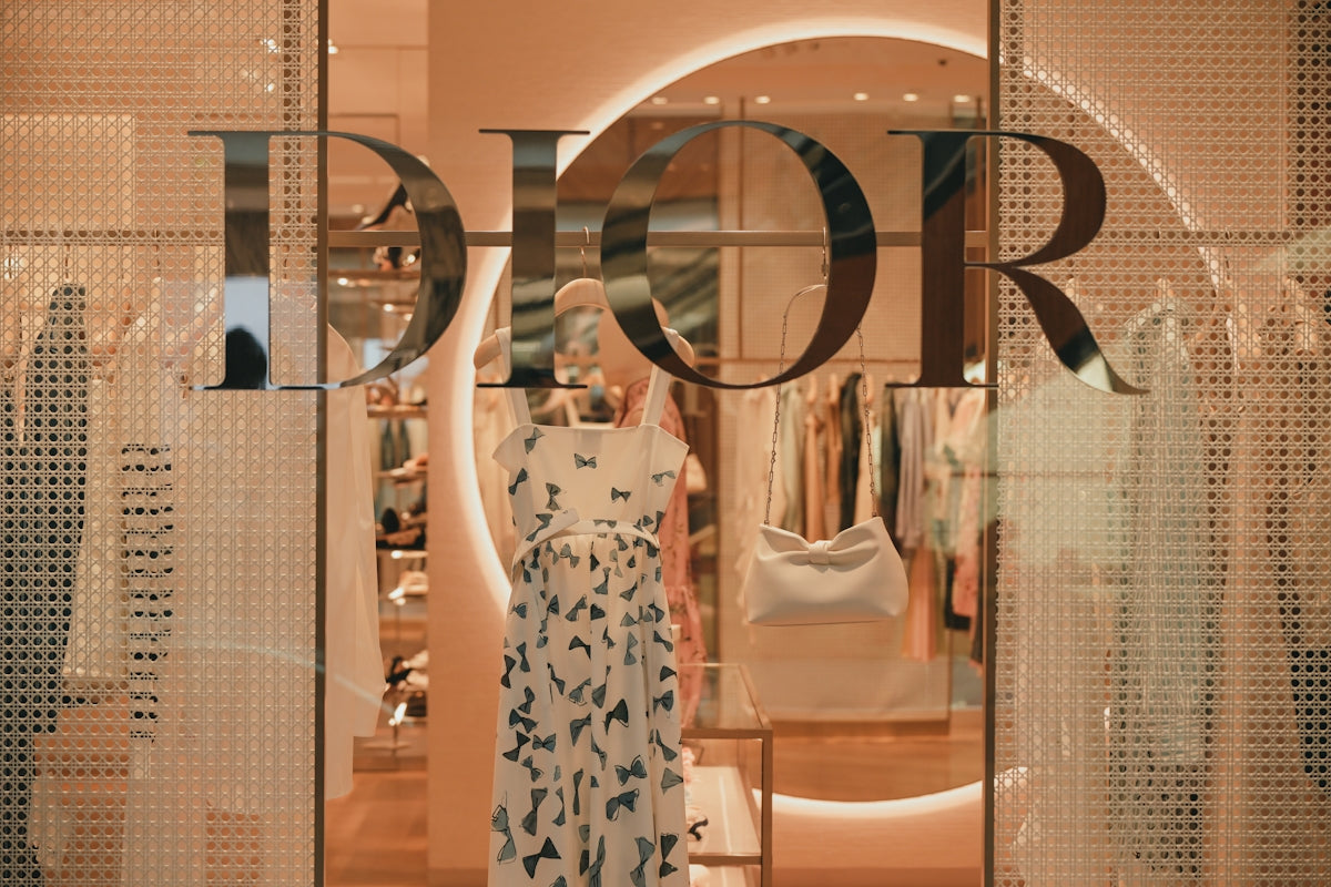 Dior storefront with a patterned dress and clothing on display.