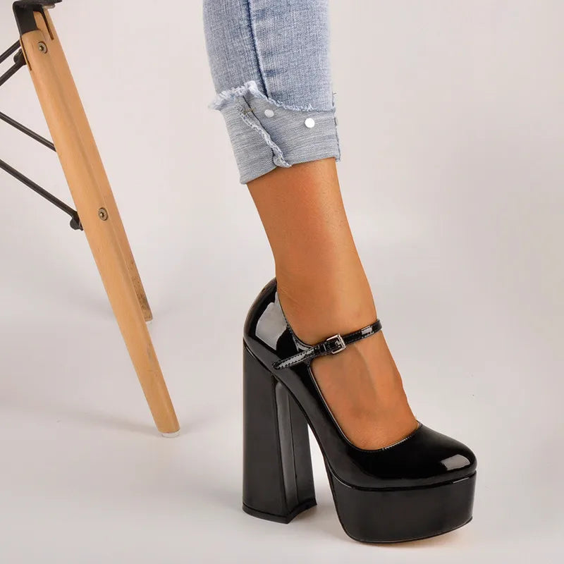 Black platform high heel shoe worn with a casual outfit on a light background