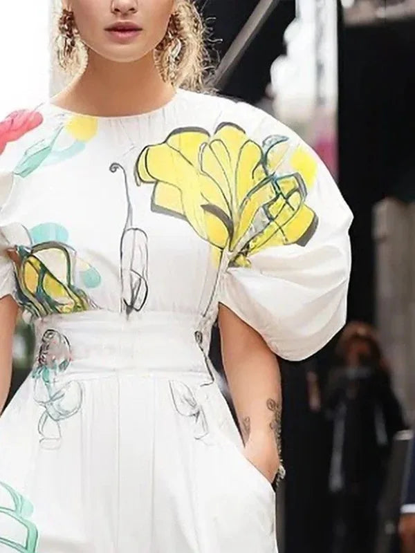 Person wearing a white outfit with colorful floral patterns in an urban setting