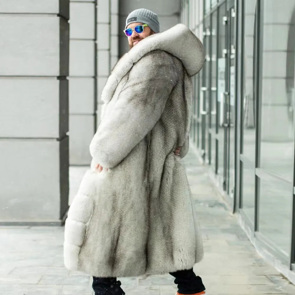 A person wearing a long, plush light gray fur coat with a large padded collar, standing in a modern urban walkway with glass buildings in the background.