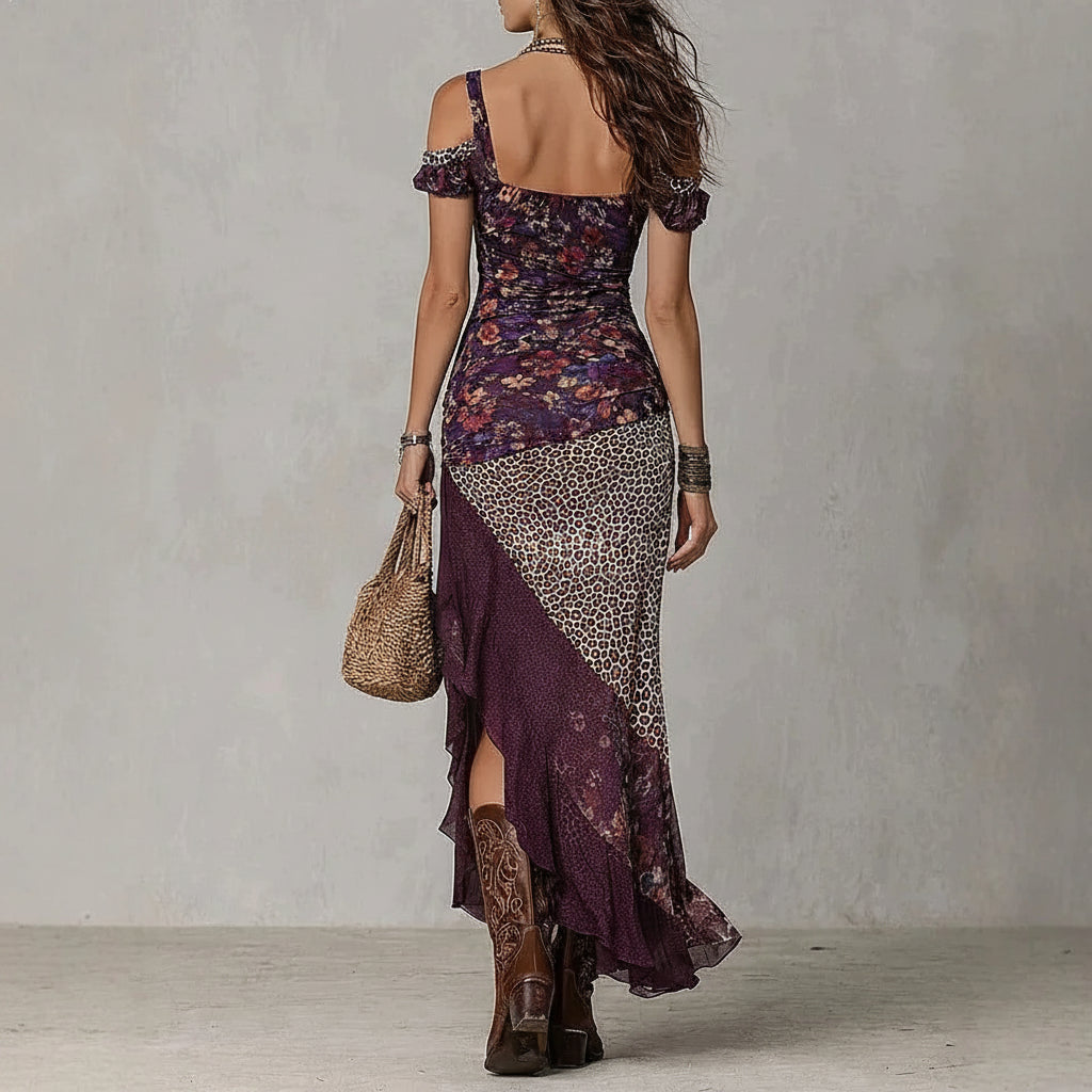 Woman wearing a floral and leopard print dress with cowboy boots against a plain background