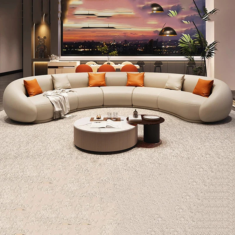 Modern living room with a curved sectional sofa, round coffee table, and cityscape artwork.