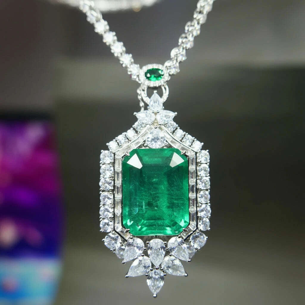 A close-up of a KQDANCE brand pendant necklace featuring a large emerald-cut green gemstone surrounded by a halo of clear cubic zirconia stones, suspended from a silver-toned chain.